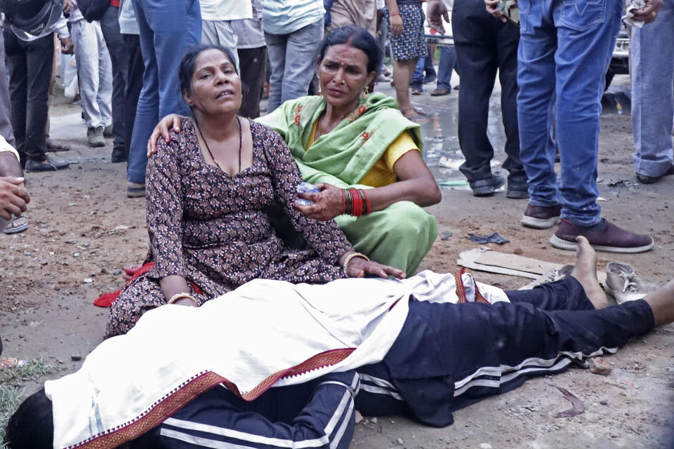 Women mourn next to the body of a relative outside the Sikandrarao hospital in Hathras district about 350 kilometers (217 miles) southwest of Lucknow, India, Tuesday, July 2, 2024. At least 60 people are dead and scores are injured after a stampede at a religious gathering of thousands of people in northern India, officials said Tuesday.(AP Photo/Manoj Aligadi)