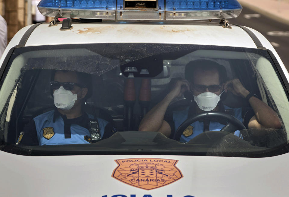 Spanish police officers patrol outside the H10 Costa Adeje Palace hotel in Tenerife, Canary Island, Spain, Tuesday, Feb. 25, 2020. Spanish officials say a tourist hotel on the Canary Islands has been placed in quarantine after an Italian doctor staying there tested positive for the new coronavirus. (AP Photo)