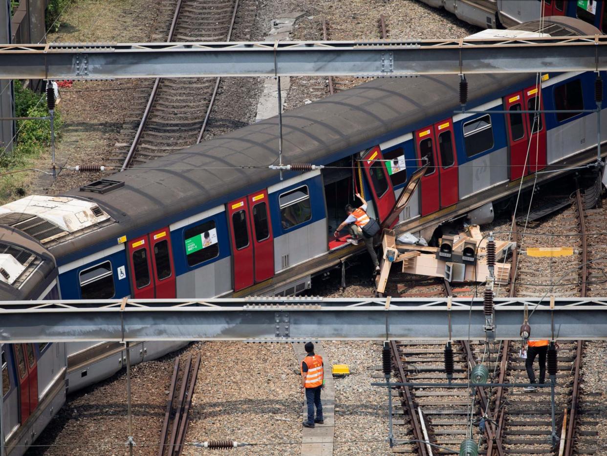 Workers investigate a derailed train in Hong Kong on 17 September 2019: EPA/JEROME FAVRE