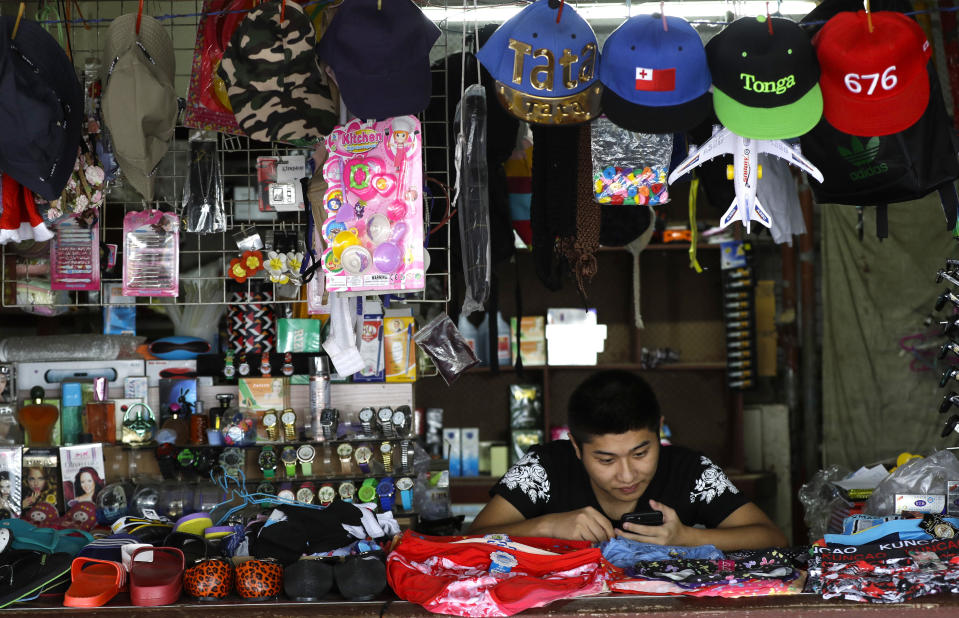 In this April 10, 2019, photo, a shopkeeper waits for business in Nuku'alofa, Tonga. China is pouring billions of dollars in aid and low-interest loans into the South Pacific, and even in the far-flung kingdom of Tonga there are signs that a battle for power and influence among much larger nations is heating up and could exact a toll. (AP Photo/Mark Baker)