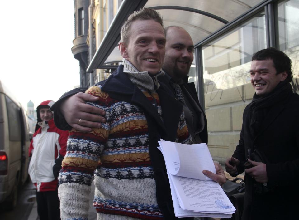 Greenpeace ship Arctic Sunrise crew member Mannes Ubels holds papers certifying the termination of prosecution after he walked out of the offices of the Federal Migration Service Department in St. Petersburg
