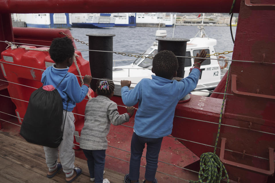 Children wave at a boat from aboard the Ocean Viking as it reaches the port of Messina, Italy, Tuesday, Sept. 24, 2019. The humanitarian ship has docked in Italy to disembark 182 men, women and children rescued in the Mediterranean Sea after fleeing Libya. (AP Photo/Renata Brito)