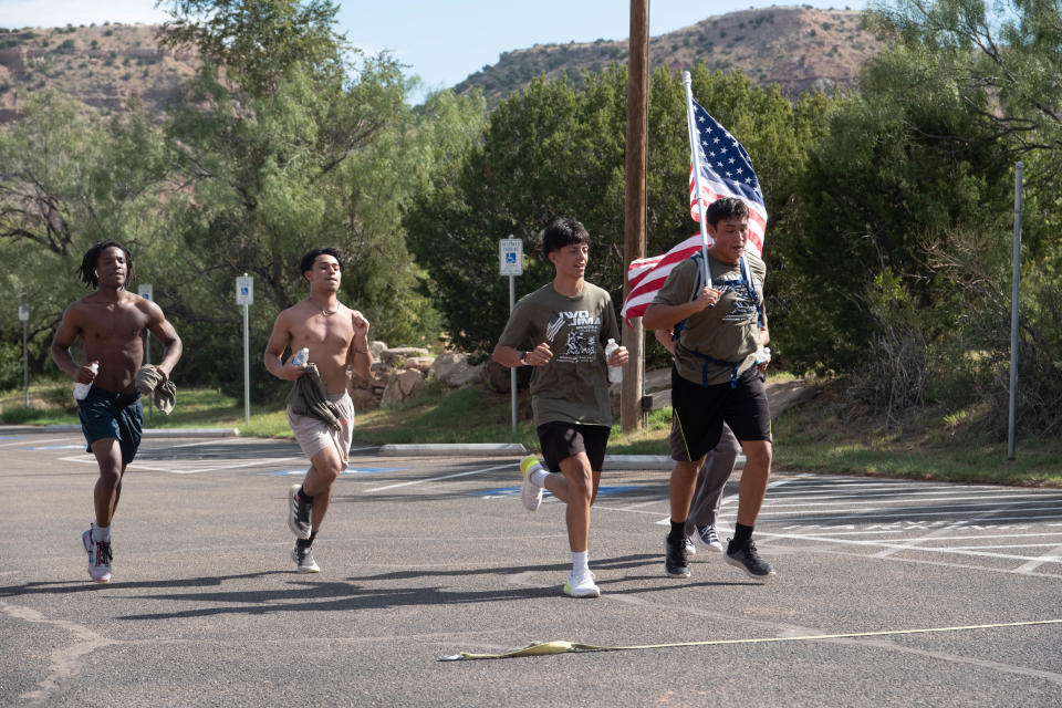 A team of high school wrestlers finish as a group at the Iwo Jima Flag Run Saturday at Palo Duro Canyon.