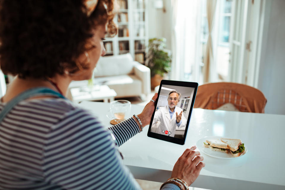 Gros plan d'une femme enceinte parlant à son médecin lors d'un appel vidéo