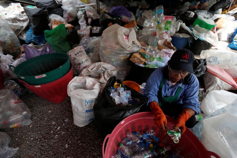 Un trabajador limpia botellas de plástico destinadas a la confección de túnicas en un monasterio de Bangkok, Tailandia, el 6 de febrero de 2020