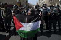 FILE - In this Sept. 27, 2013 file photo, an elderly Palestinian woman holds a Palestinian flag in front Israeli forces during a protest outside Jerusalem's old city marking the 13th anniversary of the second Palestinian uprising against Israeli occupation. Nine months of U.S.-driven diplomacy have left Israelis and Palestinians less hopeful than ever about a comprehensive peace agreement to end their century of conflict. Although a formula may yet be found to somehow prolong the talks past an end-of-April deadline, they are on the brink of collapse and the search is already on for new ideas. (AP Photo/Bernat Armangue, File)