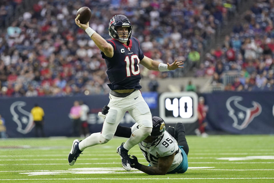 Houston Texans quarterback Davis Mills (10) is pressured by Jacksonville Jaguars defensive end Roy Robertson-Harris (95) as he passes during the first half of an NFL football game in Houston, Sunday, Jan. 1, 2023. (AP Photo/Eric Christian Smith)