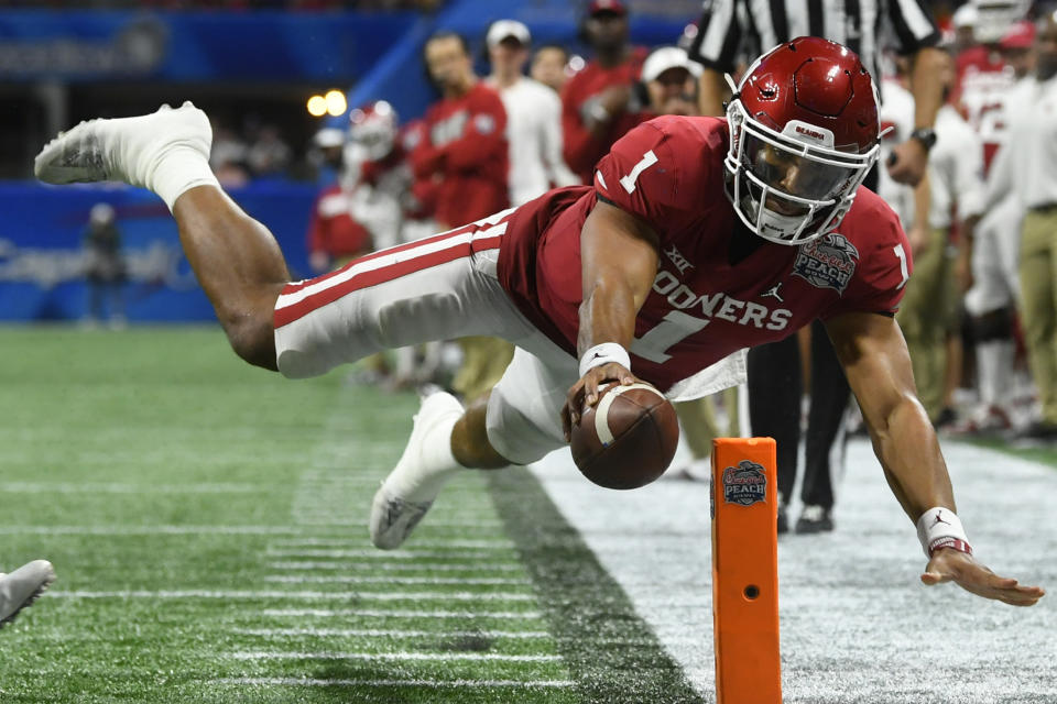 FILE - In this Dec. 28, 2019, file photo, Oklahoma quarterback Jalen Hurts (1) scores a touchdown against LSU during the second half of the Peach Bowl NCAA semifinal college football playoff game, in Atlanta. Hurts, the Heisman Trophy runner-up who once starred for Alabama, is hoping to improve his NFL draft stock at the Senior Bowl. (AP Photo/John Amis, File)