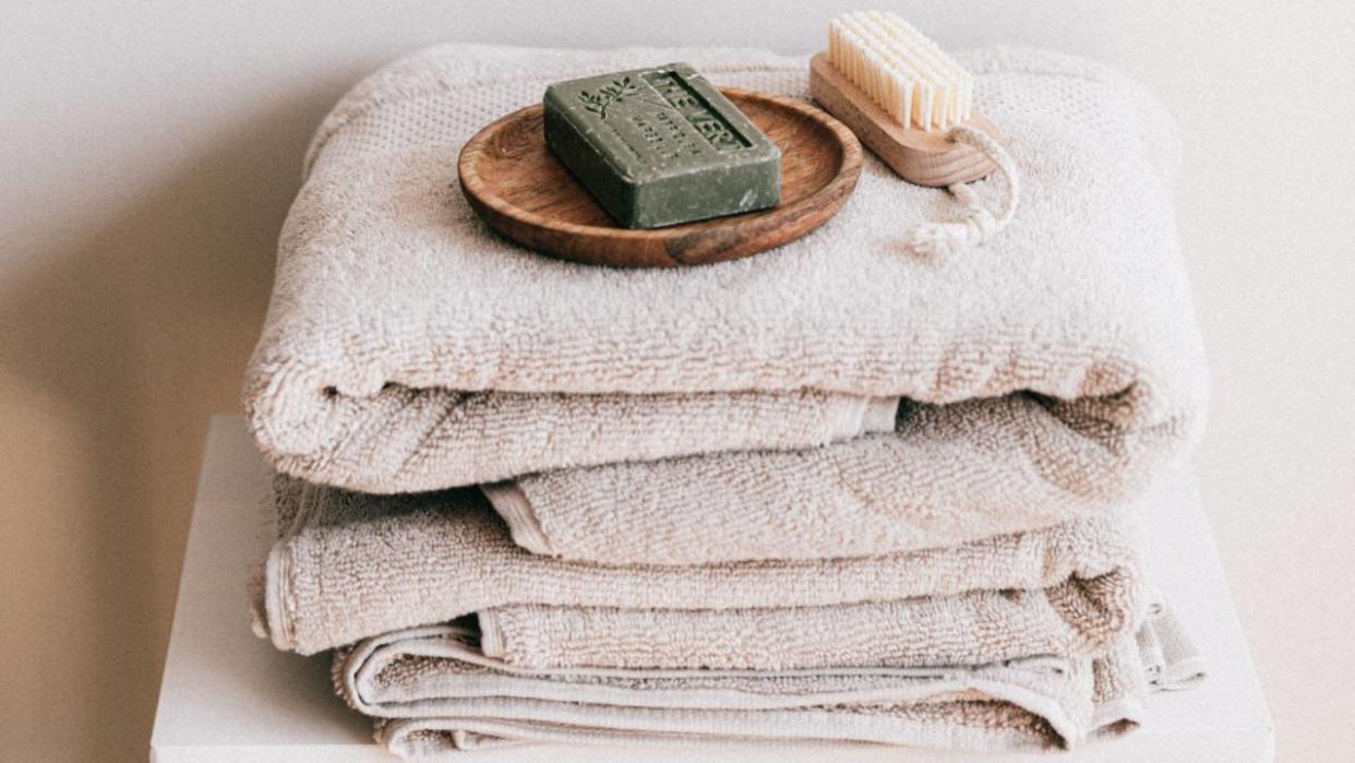  Stack of towels on a chair with soap on the top 