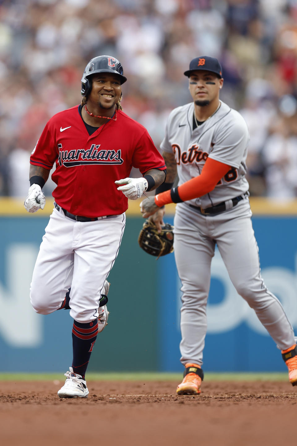 Cleveland Guardians' Jose Ramirez, left, rounds the bases after hitting a three-run home run as Detroit Tigers' Javier Baez looks on during the first inning of a baseball game Saturday, July 16, 2022, in Cleveland. (AP Photo/Ron Schwane)