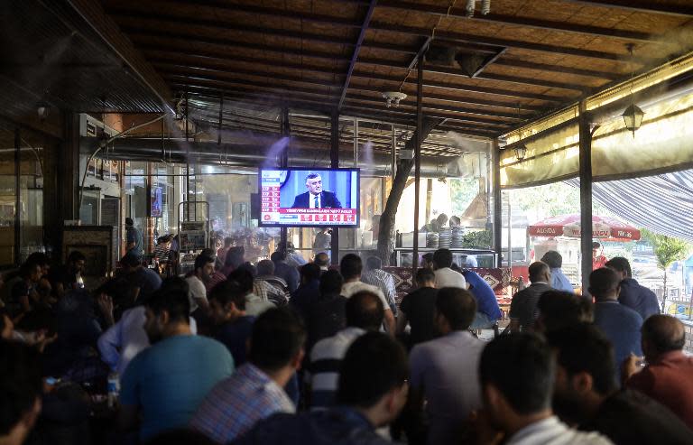 People watch results projections on television at a cafe terrace in Diyarbakir, on June 7, 2015, during the nationwide legislative polls