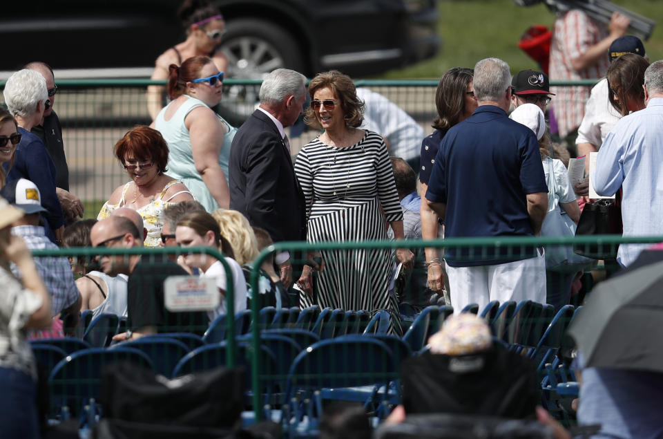 Dawn Anna, center right, the mother of Lauren Townsend who was killed in the attack on Columbine High School 20 years ago, greets Ron Mitchell, left, president of the Jefferson County, Colo., Public Schools board of Education, during a program for the victims of the massacre at Columbine Saturday, April 20, 2019, in Littleton, Colo. (AP Photo/David Zalubowski)