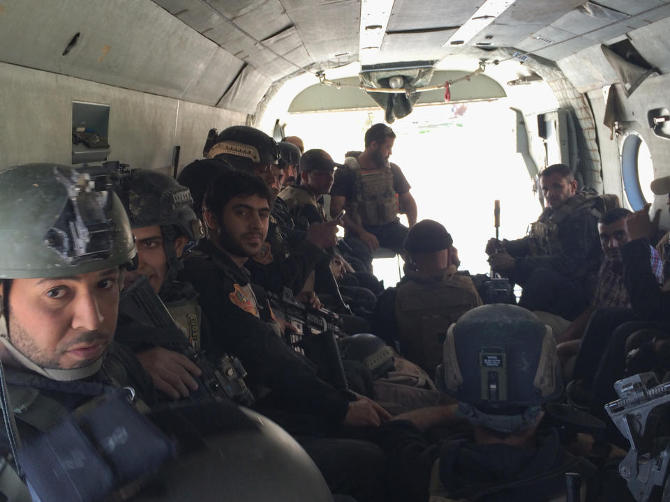 In this photo taken on March 22, 2014, Iraq's Special Weapons and Tactics Team (SWAT) ride in a helicopter on their way to take a vacation after two months of fighting with al-Qaida militants in Ramadi, 70 miles (115 kilometers) west of Baghdad, Iraq. Iraqi military officials are warning that efforts to clear militants from Fallujah and parts of nearby Ramadi are proving much more difficult than they anticipated when the jihadists showed up three months ago. That realization, as they acknowledged during a recent tour of special forces operations, casts doubt on Iraq's ability to hold elections in Fallujah next month. (AP Photo/Qassim Abdul-Zahra)