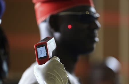 A man has his temperature taken using an infrared digital laser thermometer at the Nnamdi Azikiwe International Airport in Abuja, August 11, 2014. REUTERS/Afolabi Sotunde