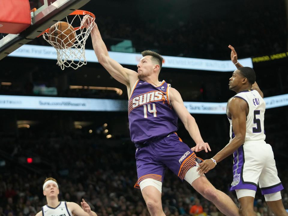 Phoenix Suns forward Drew Eubanks (14) slams two against Sacramento Kings guard De'Aaron Fox (5) during the first quarter at Footprint Center in Phoenix on Feb. 13, 2024.