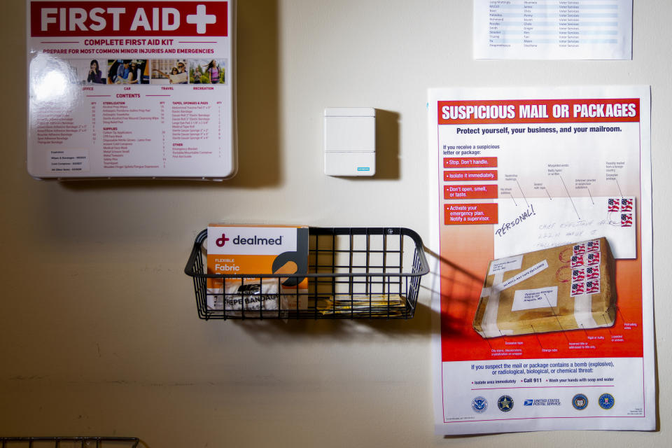 A United States Postal Service flyer about suspicious mail or packages is seen in the mail room at the King County Elections headquarters, Friday, Nov. 17, 2023, in Renton, Wash. The office began stocking Narcan, the nasal spray version of overdose-reversal drug naloxone, after receiving a letter laced with fentanyl in the summer and was evacuated the day after Election Day after receiving a similar envelope. (AP Photo/Lindsey Wasson)