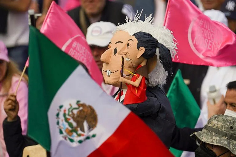 Manifestantes portan muñecos con la imagen del presidente de México, Andrés Manuel López Obrador, y de la candidata presidencial, Claudia Sheinbaum, durante una marcha convocada por organizaciones ciudadanas para exigir que se respete a la autoridad electoral en las próximas elecciones generales, el domingo 18 de febrero de 2024, en la Ciudad de México