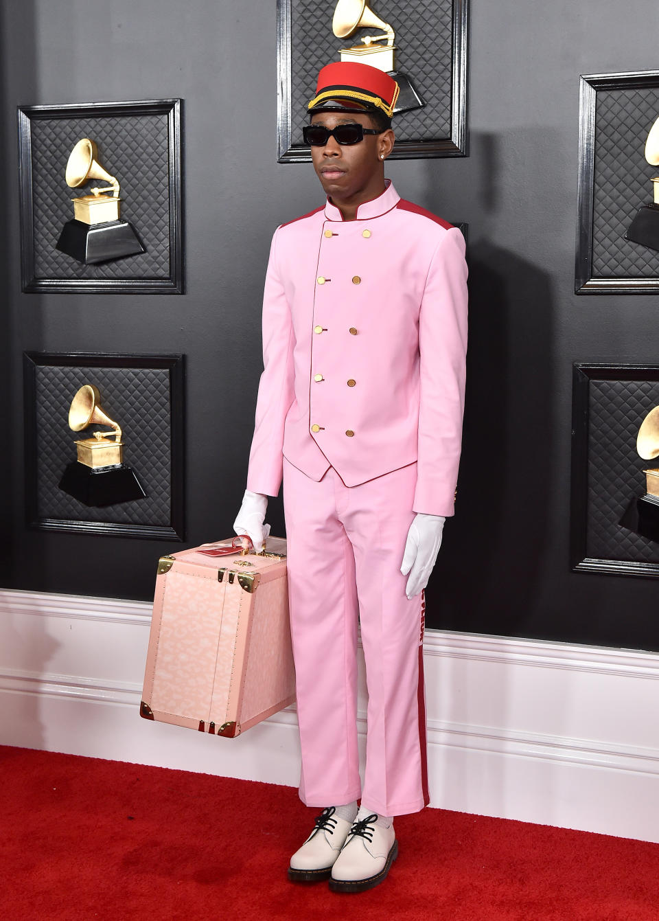 Der Gewinner des besten Rap-Albums, Tyler, The Creator, erschien zu den Grammys in einem rosa Concierge Outfit samt Koffer aus seiner eigenen Modelinie Golf Wang. In diesem verbarg sich ein weiteres Outfit, welches er später bei seiner Preis-Übergabe trug. (Bild: Axelle/Bauer-Griffin/FilmMagic)