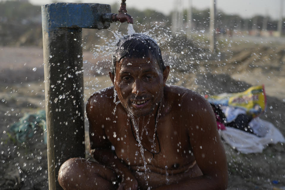 A man bathes at a public water tap near the River Ganges during a hot summer day in Prayagraj, India. Thursday, May 2, 2024. (AP Photo/Rajesh Kumar Singh)