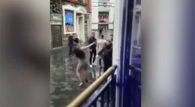 The moment the woman falls back after being punched by the man. Source: Twitter