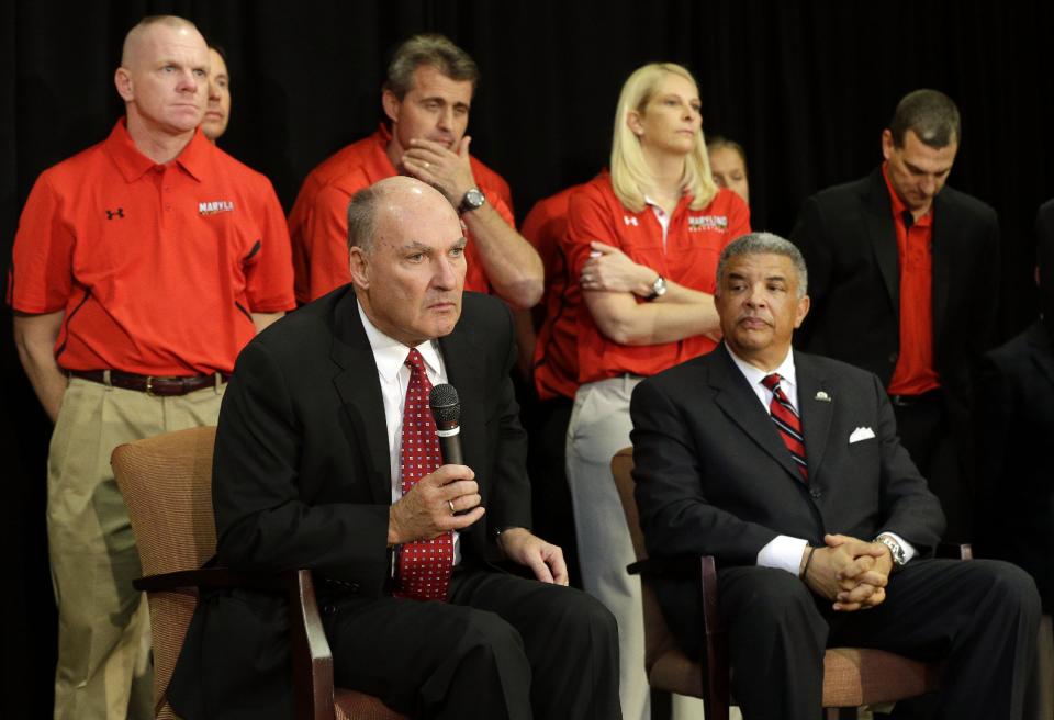 Big Ten Commissioner James Delany, front left, speaks at a news conference to announce the University of Maryland's decision to move to the Big Ten in College Park, Md., Monday, Nov. 19, 2012. Seated alongside Delany in front of Maryland coaches is athletic director Kevin Anderson. Maryland is joining the Big Ten, leaving the Atlantic Coast Conference in a shocker of a move in the world of conference realignment that was driven by the school's budget woes. (AP Photo/Patrick Semansky)