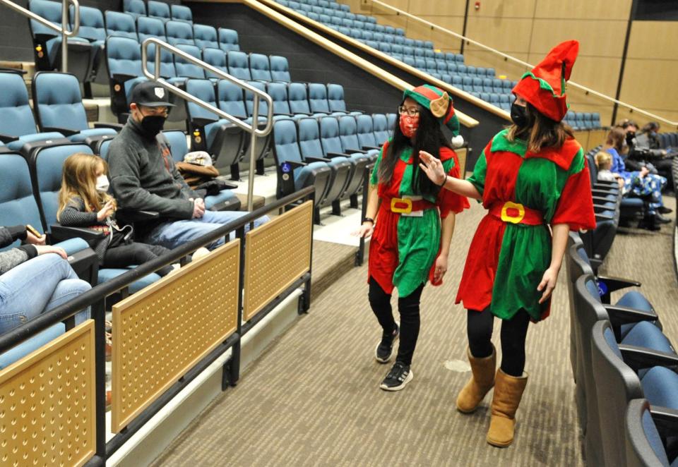 Amelia Yates, 4, left, and her dad, Steve Yates, of Scituate, are greeted by Santa's elves, Elisabeth Green, second from right, and Bailey Reimels, right, both of Scituate, during the Scituate North Pole Express Movie Experience presented by the Community of Resources for Special Education Foundation at the Scituate Center for Performing Arts on Saturday, Dec. 4, 2021.