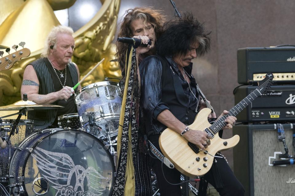 FILE - In this Aug. 15, 2018, file photo, Joey Kramer, from left, Steven Tyler and Joe Perry of Aerosmith perform on NBC's "Today" show at Rockefeller Center in New York. Kramer, a founding member of the band, filed a lawsuit against his band mates in January 2020 in Massachusetts Superior Court in Boston, claiming he has been kept out of the band after he hurt his ankle in 2019 and missed some shows. The suit comes just as the band is set to perform and be honored at Grammy Awards events. (Photo by Charles Sykes/Invision/AP, File)