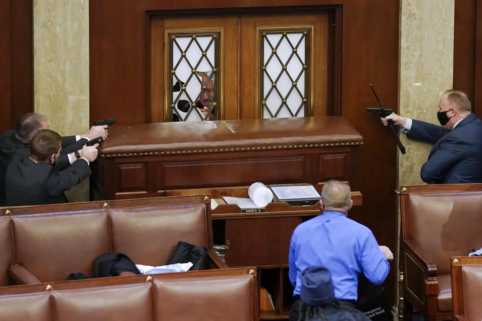 This photo by Getty Images photographer Drew Angerer, provided by Columbia University, shows U.S. Capitol police officers aiming their weapons at the main door of the House Chamber, while members of a mob supporting U.S. President Donald Trump try to gain entry, Jan. 6, 2021 in Washington, DC. Getty Images photographers Win McNamee, Drew Angerer, Spencer Platt, Samuel Corum and Jon Cherry were awarded the Pulitzer Prize for Breaking News Photography, for comprehensive and consistently riveting photos of the attack on the U.S. Capitol, in New York, Monday, May 9, 2022. (Drew Angerer/Getty Images via AP)