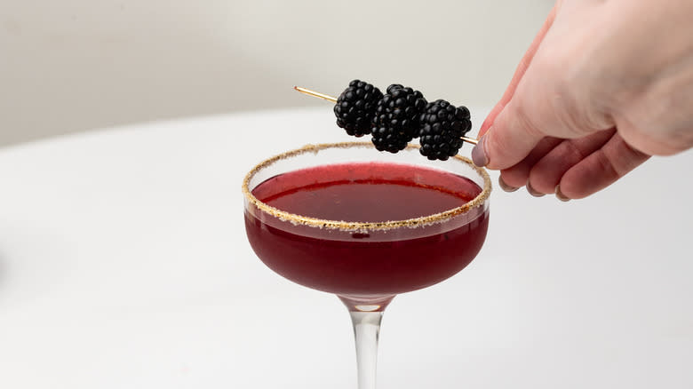 garnishing blackberry and sage margarita 