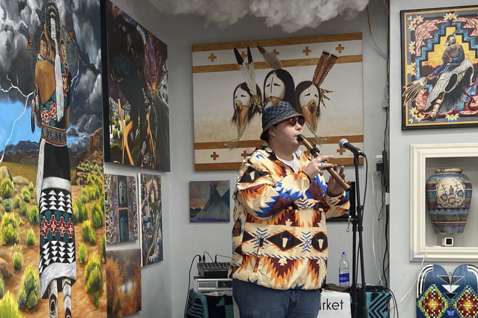 Cody Blackbird performs inside Native Art Market in Scottsdale, Ariz., on Friday, Feb. 10, 2023. Native American dancers who were the target of a racist rant by Gilbert Ortega Jr., a suburban Phoenix gallery owner, as they were being filmed for Super Bowl week are pushing for hate crime charges. Blackbird, a dancer and flutist who filmed the man's tirade, said his group doesn't feel safe. The confrontation has ruined what should have been a celebratory week. (AP Photo/Alina Hartounian)