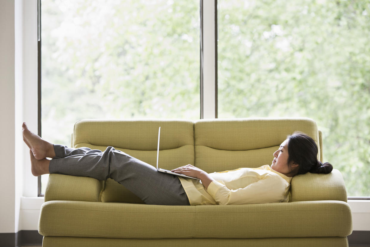 Japanese businesswoman using laptop on sofa