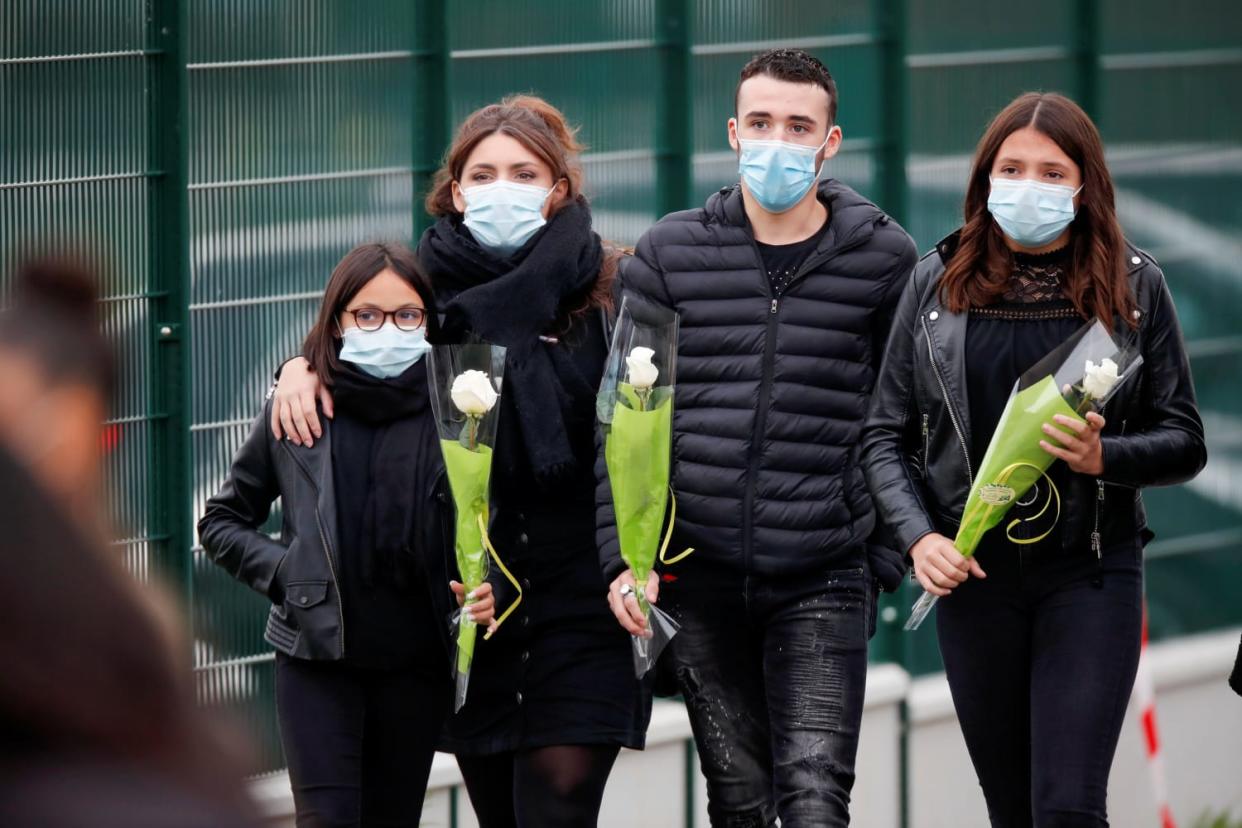 Image: People bring flowers to the Bois d'Aulne college after the attack in the Paris suburb of Conflans St Honorine (CHARLES PLATIAU / Reuters)
