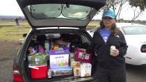 In this image taken from video, Nicole Skilling of Captain Cook, Hawaii stands next to her packed car as she visits Mauna Loa volcano's eruption site in Hilo, Hawaii, Monday, Nov. 28, 2022. Skilling lived near the site of the 2018 Kilauea eruption and moved to the South Kona area, which is another high risk zone for volcanic activity. (AP Photo/Caleb Jones)