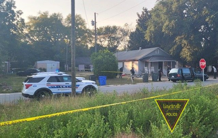 The Fayetteville Police Department vehicles on a portion of Powell Street where two women were found with gunshot wounds. Both women survived, but the child being carried by one of the victim's died after being delivered by emergency cesarean section, police said.