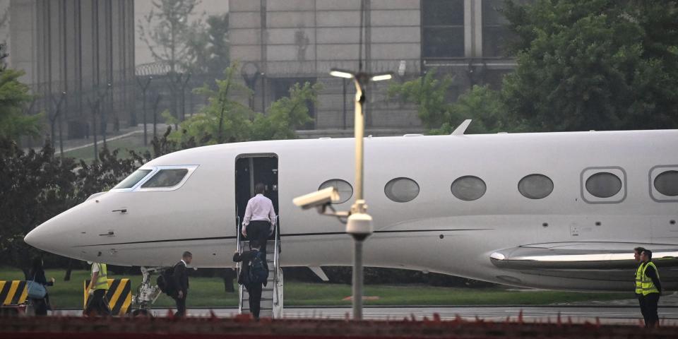 A long distance shot of Tesla Chief Executive Officer Elon Musk in a white shirt, boards his private jet before departing from Beijing Capital International Airport on May 31, 2023.