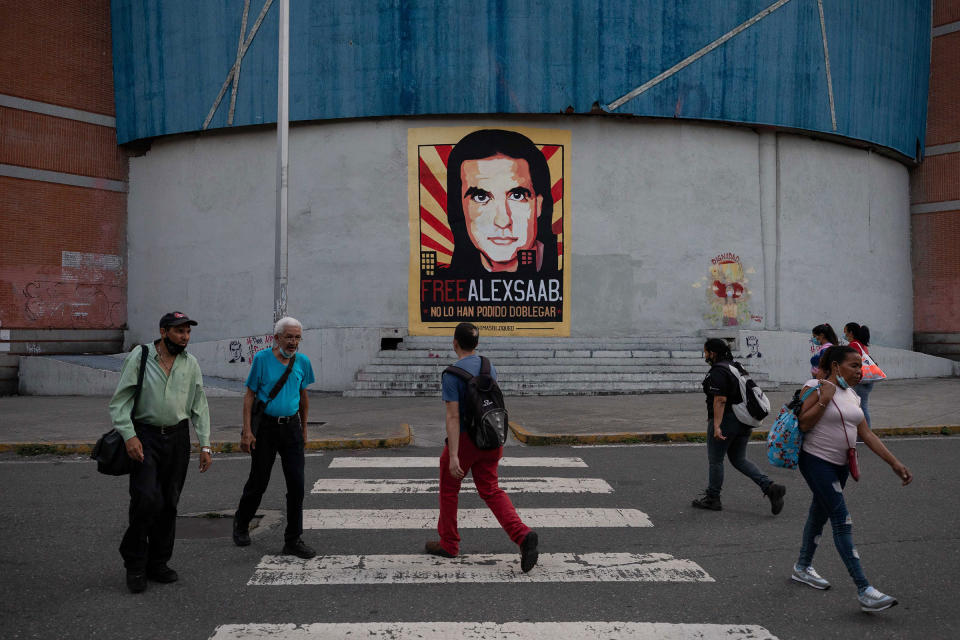 People walk in front of a mural with the image of Alex Saab in Caracas, Venezuela, October 25, 2021.<span class="copyright">Rayner Pena—EPA-EFE/Shutterstock</span>