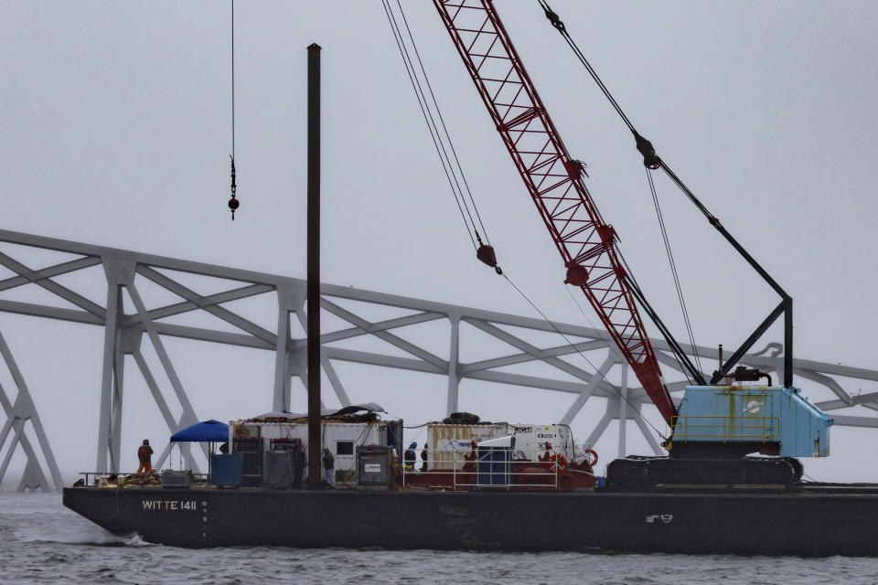Cranes continue salvage work as wreckage of the Francis Scott Key Bridge rests on the container ship Dali, Wednesday, April 3, 2024, in Baltimore. (AP Photo/Julia Nikhinson)