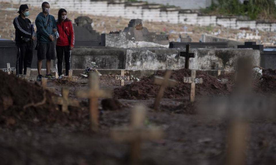 Relatives attend the burial of a family member who died from coronavirus in Rio de Janeiro. More than 9,000 people have died of the illness in Brazil.