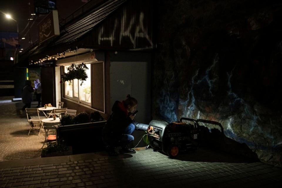 A woman looks at a generator that powers a cafe if there is a power cut on Nov.5, 2022 in Kyiv, amid power outages due to Russia's attacks on the electric grid. (Ed Ram/Getty Images)