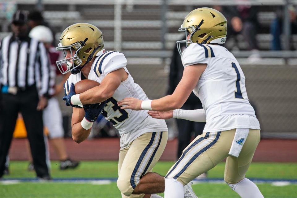 Salesianum sophomore Ryan Stoehr (1) hands off the ball to junior Aiden Lego (23) against Hodgson during the football game at St. Georges High football stadium in Middletown, Saturday, Nov. 4, 2023. Salesianum won 38-19.