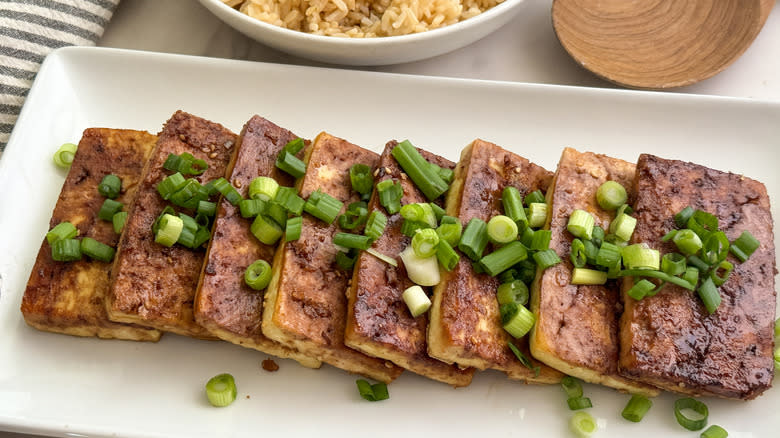 sliced tofu on tray with scallions