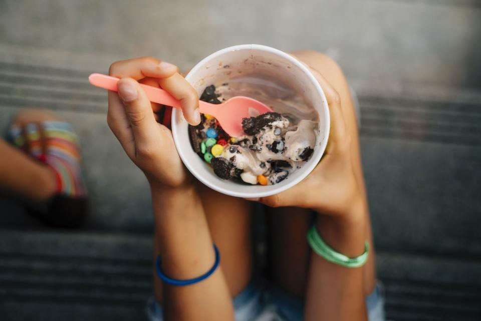 high angle close up of girl sitting on steps eating ice cream