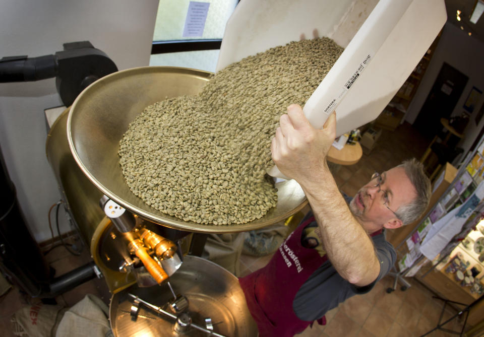 Green coffee beans (actually seeds) are poured into a roaster at Hansen Coffee Rosters in Roedermark, Germany. (Photo: picture alliance via Getty Images)