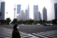 A woman wearing a protective mask is seen in Shanghai, China, as the country is hit by a novel coronavirus outbreak, at the Pudong financial district in Shanghai