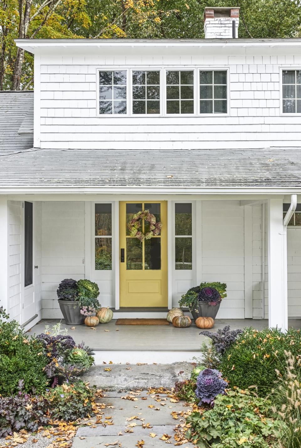 a white farmhouse with a yellow door