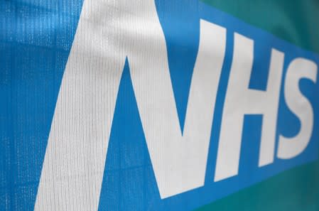An NHS logo is displayed outside a hospital in London
