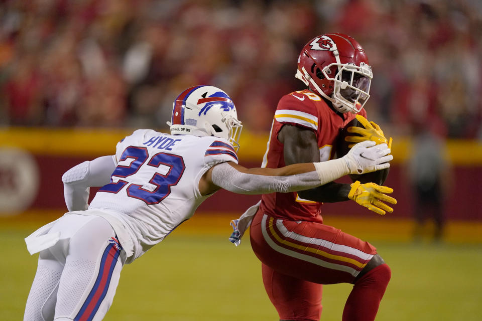 Kansas City Chiefs wide receiver Tyreek Hill, right, runs with the ball as Buffalo Bills safety Micah Hyde defends during the first half of an NFL football game Sunday, Oct. 10, 2021, in Kansas City, Mo. (AP Photo/Charlie Riedel)