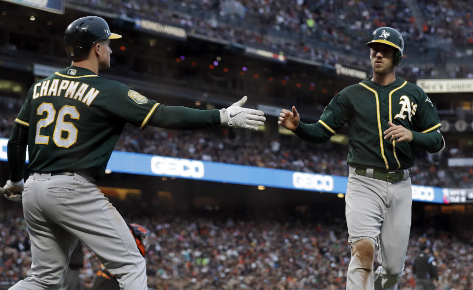 Oakland Athletics’ Stephen Piscotty (R) is high-fived by Matt Chapman after Piscotty scored on a sacrifice fly by Khris Davis during the third inning of a baseball game Saturday, July 14, 2018, in San Francisco. (AP)