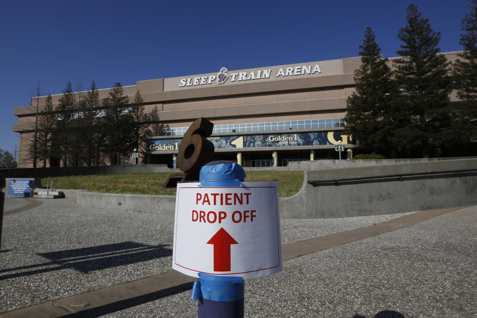FILE - In this April 18, 2020, file photo, a temporary sign is placed at Sleep Train Arena that has been turned into a 400-bed emergency field hospital to help deal with the coronavirus, in Sacramento, Calif. Due to the recent spike in COVID-19 cases officials are rushing to reopen the former home of the NBA's Sacramento Kings, to patients. (AP Photo/Rich Pedroncelli, File)