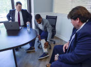 FILE - In this on Aug. 5, 2020, file photo, Jeffery Ryans points at his ankle as he discusses his encounter with Salt Lake City police at his attorney's office, in Salt Lake City. A Utah police officer was charged with aggravated assault after ordering a dog to attack Ryans who had put his hands in the air, prosecutors announced Wednesday, Sept. 16, 2020. Ryans was in his backyard on April 24 when police responded to a domestic dispute call. (Leah Hogsten/The Salt Lake Tribune via AP, Filw)